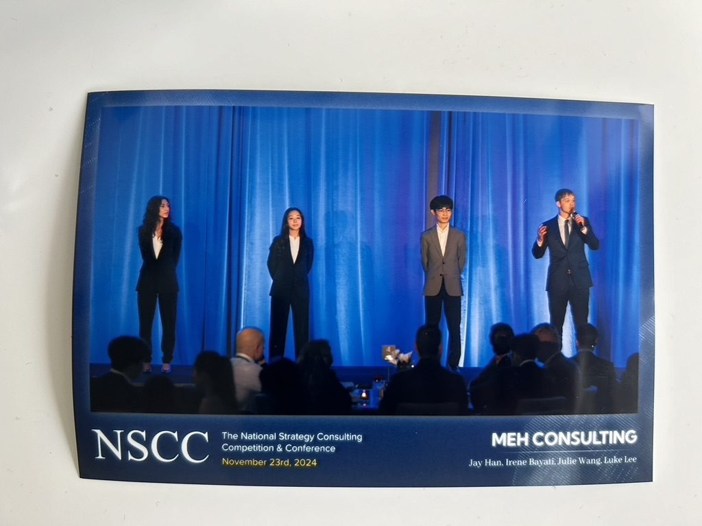 Four students presenting on stage at the National Strategy Consulting Competition