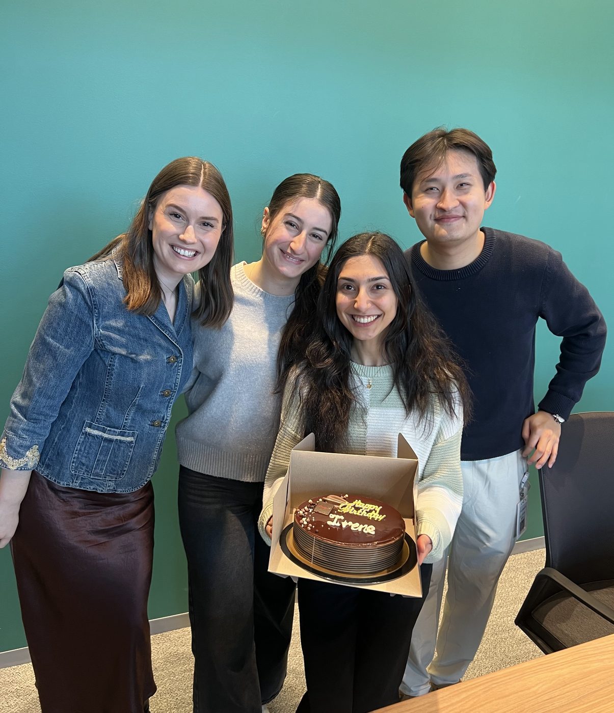 Four colleagues with a birthday cake