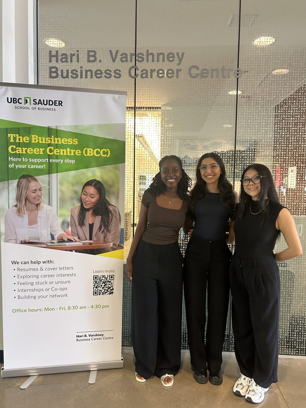 Three colleagues beside a Business Career Centre banner