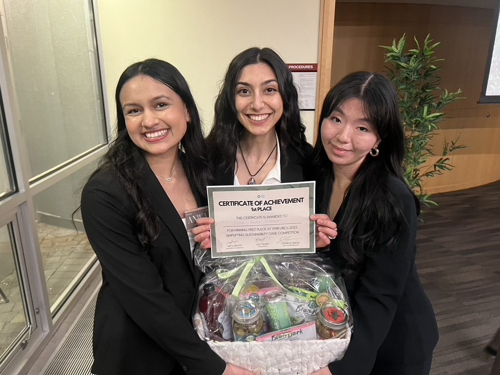 Three students holding a first place certificate and a gift basket